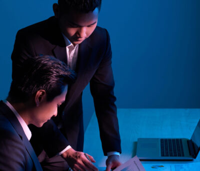 Business colleagues having discussion on start-up project in dark office